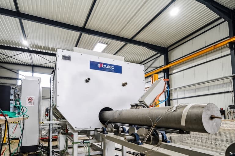 Extrutec log brushing system with an aluminium log entering the brushing chamber.